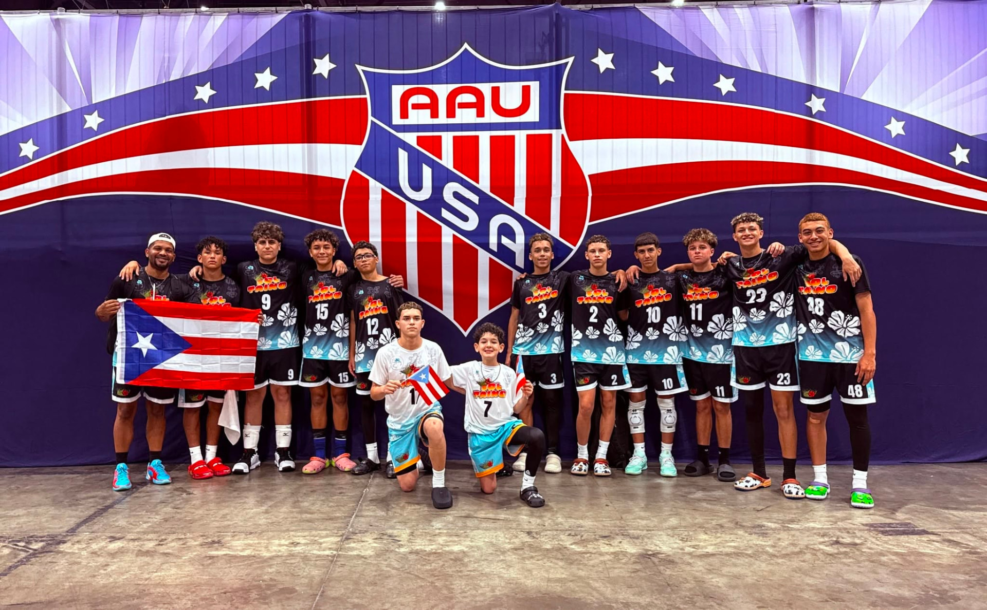 Jugadores de Sol Taíno Volleyball Club posando con la bandera de Puerto Rico en un torneo nacional